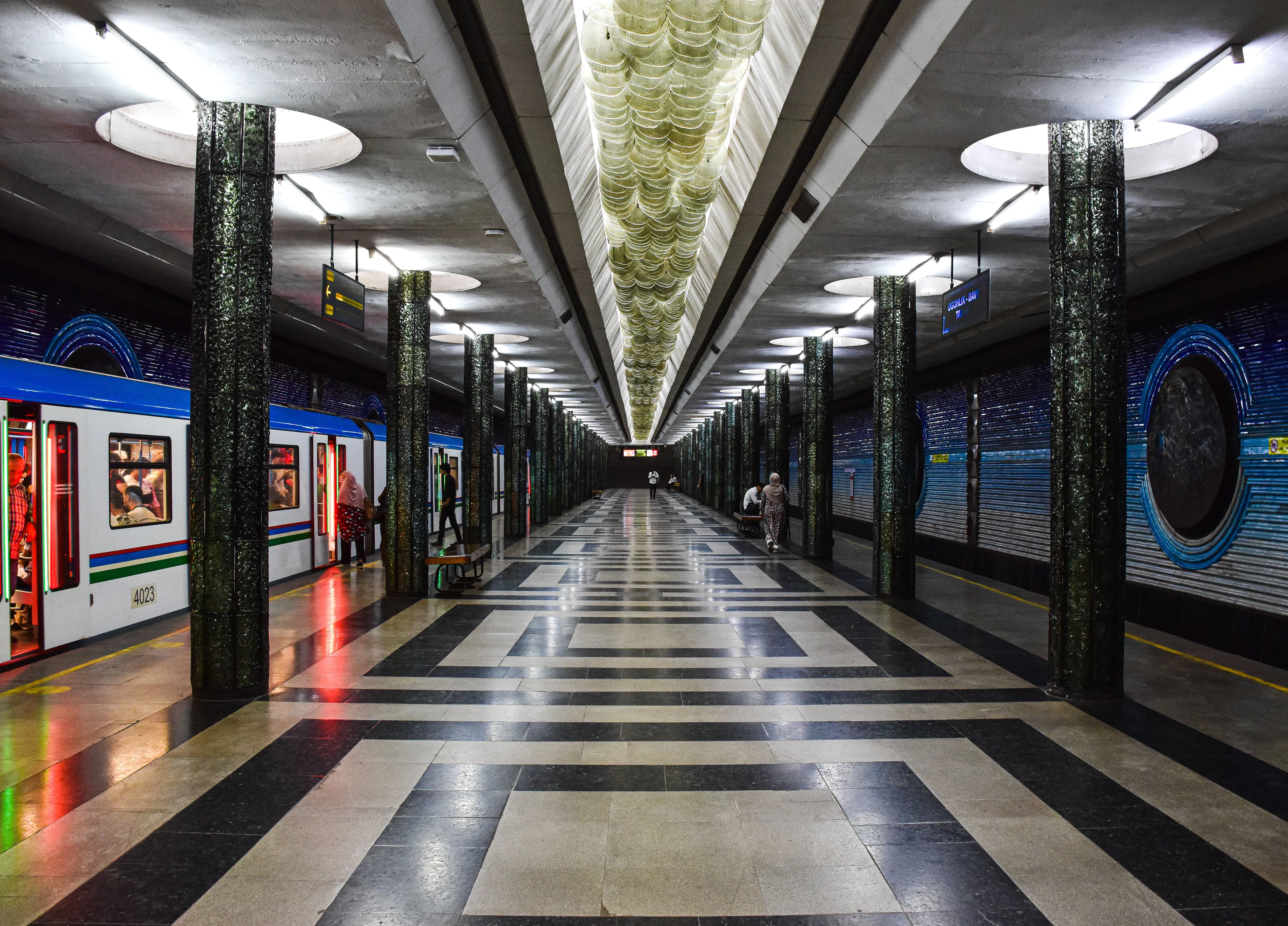 A Tashkent metro station with dark stone columns and a patterned floor